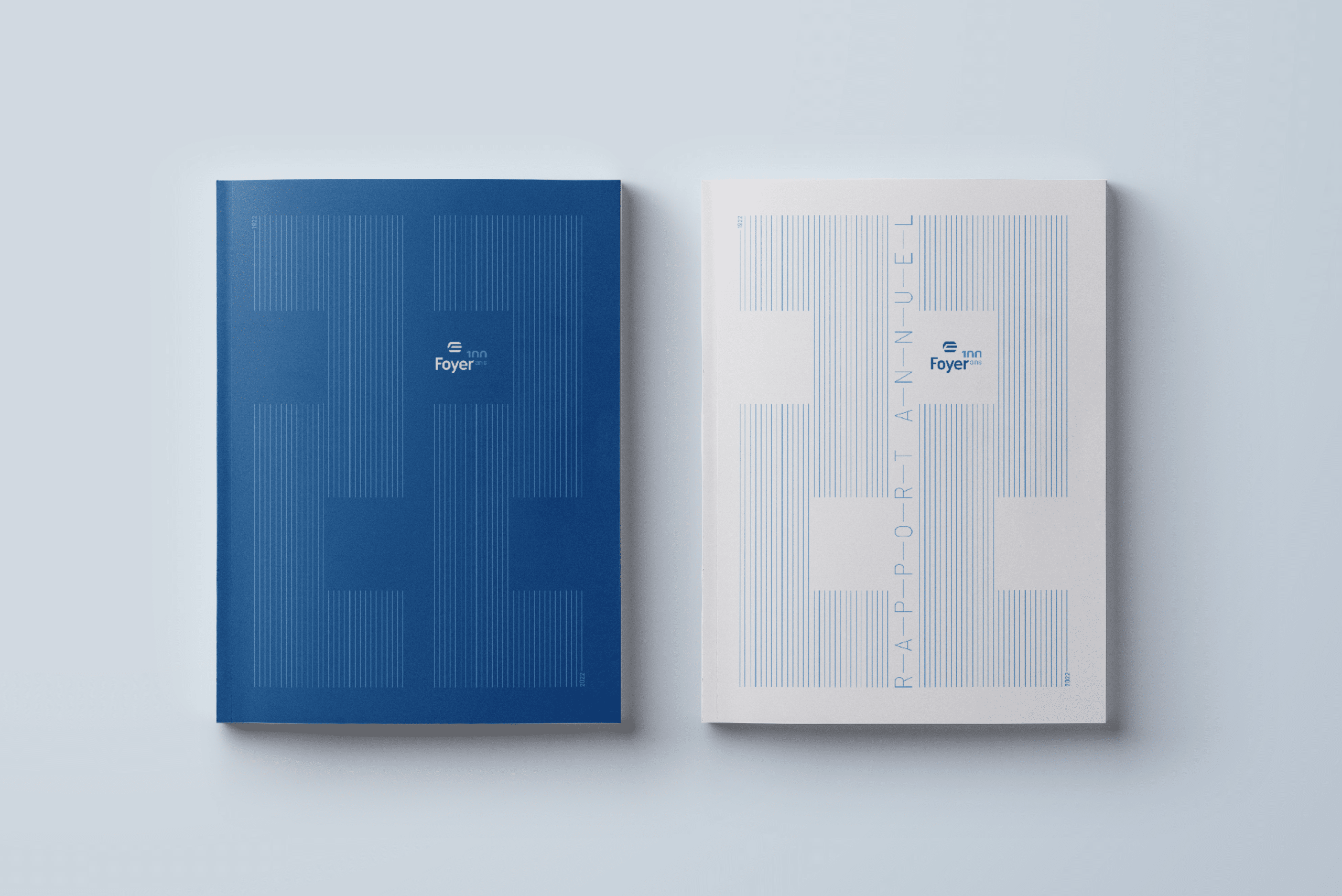 Deux rapports annuels 2022 côte à côte, un avec une couverture bleue et l'autre blanche, tous deux avec des motifs de lignes verticales et le logo de Foyer en haut.